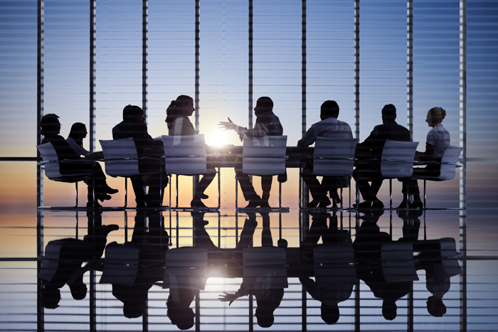 Staff Members silhouetted in conference room at large table